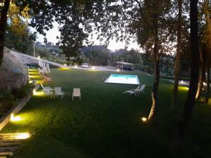 a backyard with a swimming pool and chairs and lights at Quinta das Essências in Penafiel
