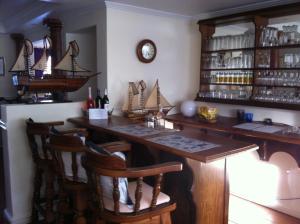 eine Bar mit einem Holztisch und Stühlen in der Unterkunft Birkenhead Manor in Bloubergstrand