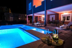 カシュテラにあるXXL Luxury villa near Split for up to 16 peopleの夜間のスイミングプール付きハウス