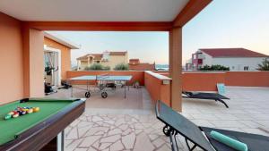 Apartman Rita with pool في قشتيلا: شرفة مع طاولة بلياردو في الفناء