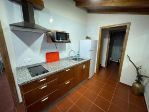 eine Küche mit einer Theke, einer Spüle und einem Kühlschrank in der Unterkunft Casa Camino Los Chorros in Vallehermoso