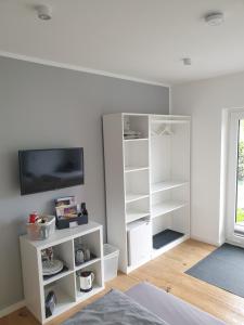 a room with white shelves and a tv at Willkommen zu Hause, ankommen & wohlfühlen ! in Tremsbüttel