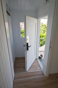 an open white door in a room with a porch at Lake Getaway Apartment with Private entrance, right on the Lake Constance cycle path, barbecue area, free wifi, Netflix and free bikes in Salmsach