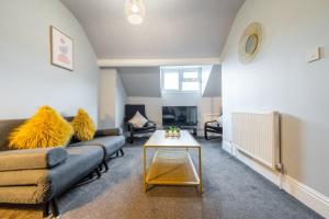 ein Wohnzimmer mit Sofa und Tisch in der Unterkunft Sheffield Contractors Stays- Sleeps 6, 3 bed 3 bath house. Managed by Chique Properties Ltd in Brightside