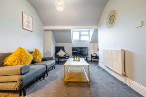 a living room with a couch and a table at Sheffield Contractors Stays- Sleeps 6, 3 bed 3 bath house. Managed by Chique Properties Ltd in Brightside