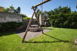 eine Schaukel im Garten mit einem Picknicktisch in der Unterkunft Lake Getaway Apartment with Private entrance, right on the Lake Constance cycle path, barbecue area, free wifi, Netflix and free bikes in Salmsach