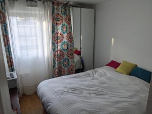 een kleine slaapkamer met een bed en een raam bij Appartement lumineux Seine, île St-Germain, proche Porte de Versailles et la Défense in Issy-les-Moulineaux
