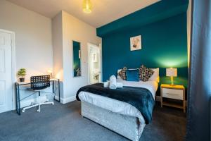ein Schlafzimmer mit einem Bett und einer blauen Wand in der Unterkunft Sheffield Contractors Stays- Sleeps 6, 3 bed 3 bath house. Managed by Chique Properties Ltd in Brightside