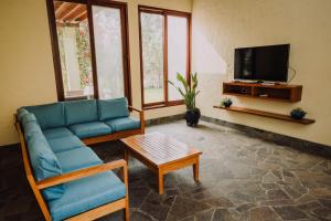uma sala de estar com um sofá azul e uma televisão em Casa de Campo en Cieneguilla em Lima