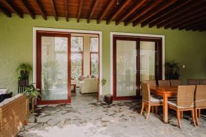 Zimmer mit einem Tisch, Stühlen und einer grünen Wand in der Unterkunft Casa de Campo en Cieneguilla in Lima