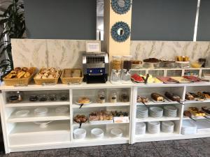 una vetrina di panetteria con vari prodotti da forno e una macchinetta del caffè di Hotel Florida ad A Lanzada