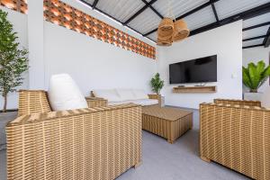 a living room with wicker furniture and a tv at Ayenda Medallo City in Medellín