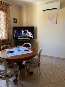 een woonkamer met een tafel en een televisie bij Casa di Paola mare Ardea in Ardea