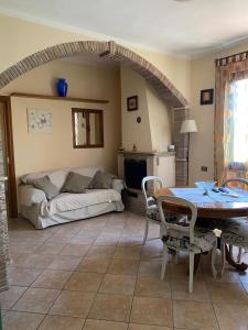 een woonkamer met een bank en een tafel bij Casa di Paola mare Ardea in Ardea