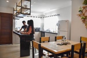 a man and woman standing at a counter in a kitchen at Sun Cottage - Mar Adentro in Santa Cruz de la Sierra