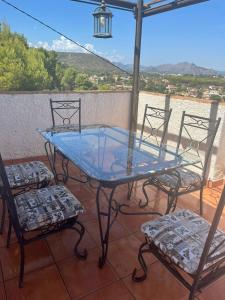 a glass table and two chairs on a patio at Villa vistas panorámicas in Denia
