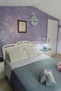 a bedroom with a bed with a purple wall at Casa vacanze Montereale in Realmonte