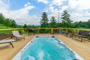 une piscine sur une terrasse avec des chaises et une table dans l'établissement Weekend friends and fam! Media room, Hot Tub, Firepit, Sleeps 18 minutes to Asheville, à Weaverville