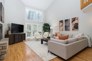 a living room with a couch and a tv at Secluded oasis in Asheville! GAME room MOVIE theater HOT tub - 20 min to Biltmore! in Fairview