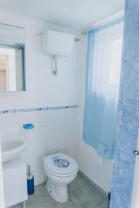 a white bathroom with a toilet and a sink at Casa vacanze Montereale in Realmonte