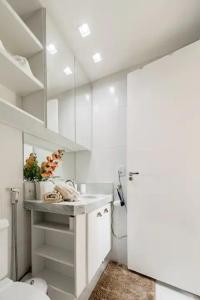 a white bathroom with a sink and a toilet at Suite Verano Stay in Rio de Janeiro