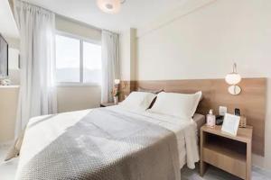 Un dormitorio blanco con una cama grande y una ventana en Suite Verano Stay en Río de Janeiro