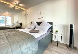 a bedroom with a large bed with a laptop on it at Auszeit Apartment STYLE in Friedrichshafen