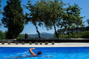 Una donna stesa in acqua in una piscina di Casa da Muiñeira a Cambados