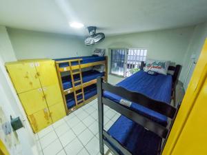 a dorm room with two bunk beds and a window at Aloha Hostel Pinhões in Fortaleza