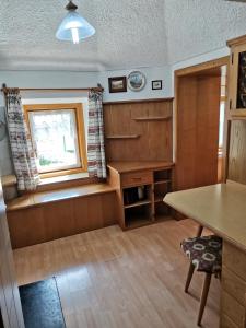 ein Wohnzimmer mit einem Tisch und einem Fenster in der Unterkunft Appartamento Col di Lana Dolomites in Livinallongo del Col di Lana