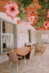 a wooden table and chairs in a room at Vila Milo in Himare