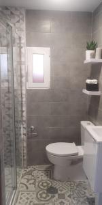 uma casa de banho com um WC e um chuveiro em Tranquila casa con patio em Vigo