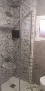 um chuveiro com uma porta de vidro na casa de banho em Tranquila casa con patio em Vigo