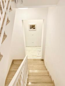 a staircase in a house with white walls and wooden floors at IL VIAGGIATORE RELAIS SUL MARE in Gaeta