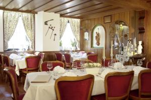 a restaurant with white tables and red chairs at Alte Weinschänke in Ellenz-Poltersdorf