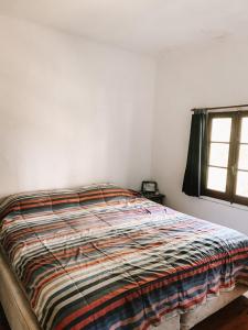 a bed in a white room with a window at Casa Chichipio in Tigre