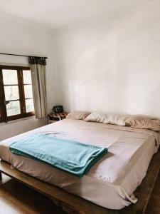 a bed with a blue blanket on it in a bedroom at Casa Chichipio in Tigre