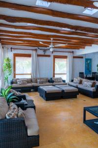 Casa Luz Beach Front Holbox في جزيرة هول بوكس: غرفة معيشة كبيرة مع كنب وطاولات