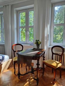 a dining room with a table and chairs and windows at BE IN GDANSK Apartments - IN THE HEART OF THE OLD TOWN - Szeroka 61/63 in Gdańsk