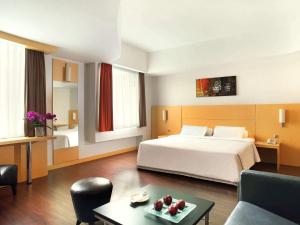 a hotel room with a bed and a table with fruit at Ibis Jakarta Arcadia in Jakarta