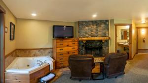 a bathroom with a tub and a tv and a television at Callahan's Lodge in Ashland