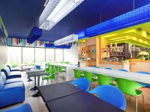 a restaurant with green and blue chairs and tables at Ibis Budget Jakarta Daan Mogot in Jakarta
