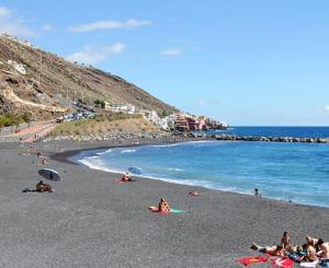 un gruppo di persone sdraiate su una spiaggia di THE POPPIES Joy of Living by The Ocean! a Candelaria