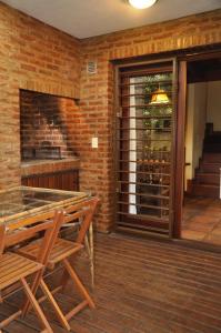 a room with a fireplace and a table and chairs at Calamoresca Complejo de Cabanas in Mar de las Pampas