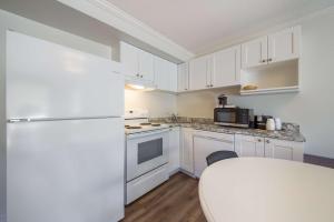 uma cozinha com armários brancos e um frigorífico branco em SureStay Hotel by Best Western Rossland Red Mountain em Rossland