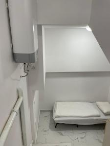 a small white room with a bed in the corner at Downtown Core Apartments in Budapest