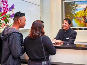 three people standing around a counter with a man at ibis budget Singapore Joo Chiat in Singapore