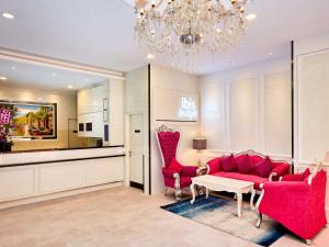 a living room with red furniture and a chandelier at ibis budget Singapore Joo Chiat in Singapore