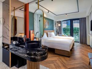 a hotel room with a bed and a mirror at Tribe Bali Kuta Beach in Kuta