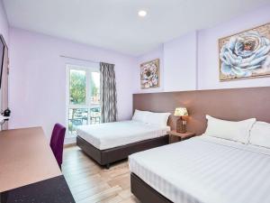 Habitación de hotel con 2 camas y mesa en ibis budget Singapore Joo Chiat en Singapur